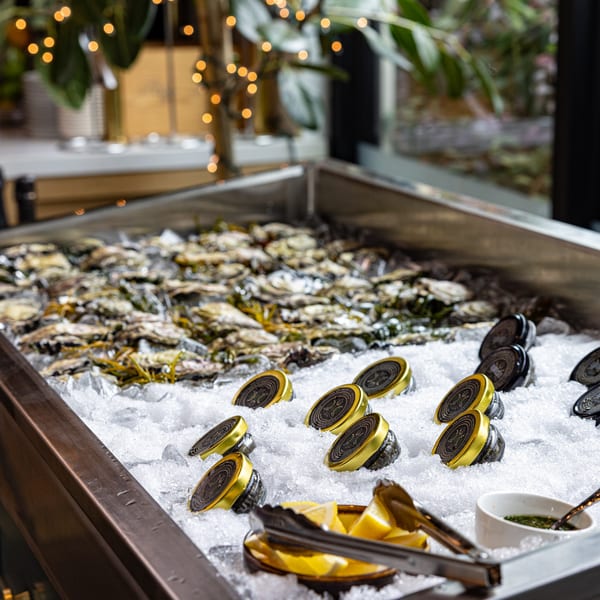 Oysters and caviar jars on ice, with lemon wedges and sauce, at Crush'd Wine Bar Kitchen.