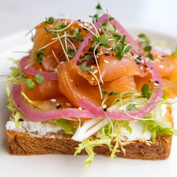 A New-American smoked salmon toast with pickled red onions, microgreens, and everything bagel seasoning.